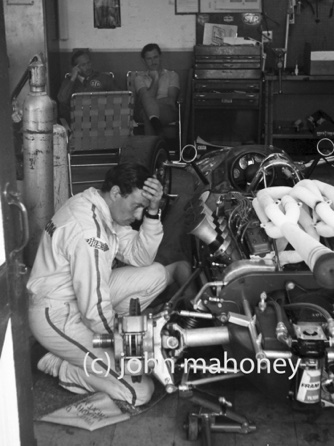 Jim est soucieux car la monoplace ne fonctionne pas convenablement, au fond du garage, Colin Chapman et Graham Hill...
© John Mahoney